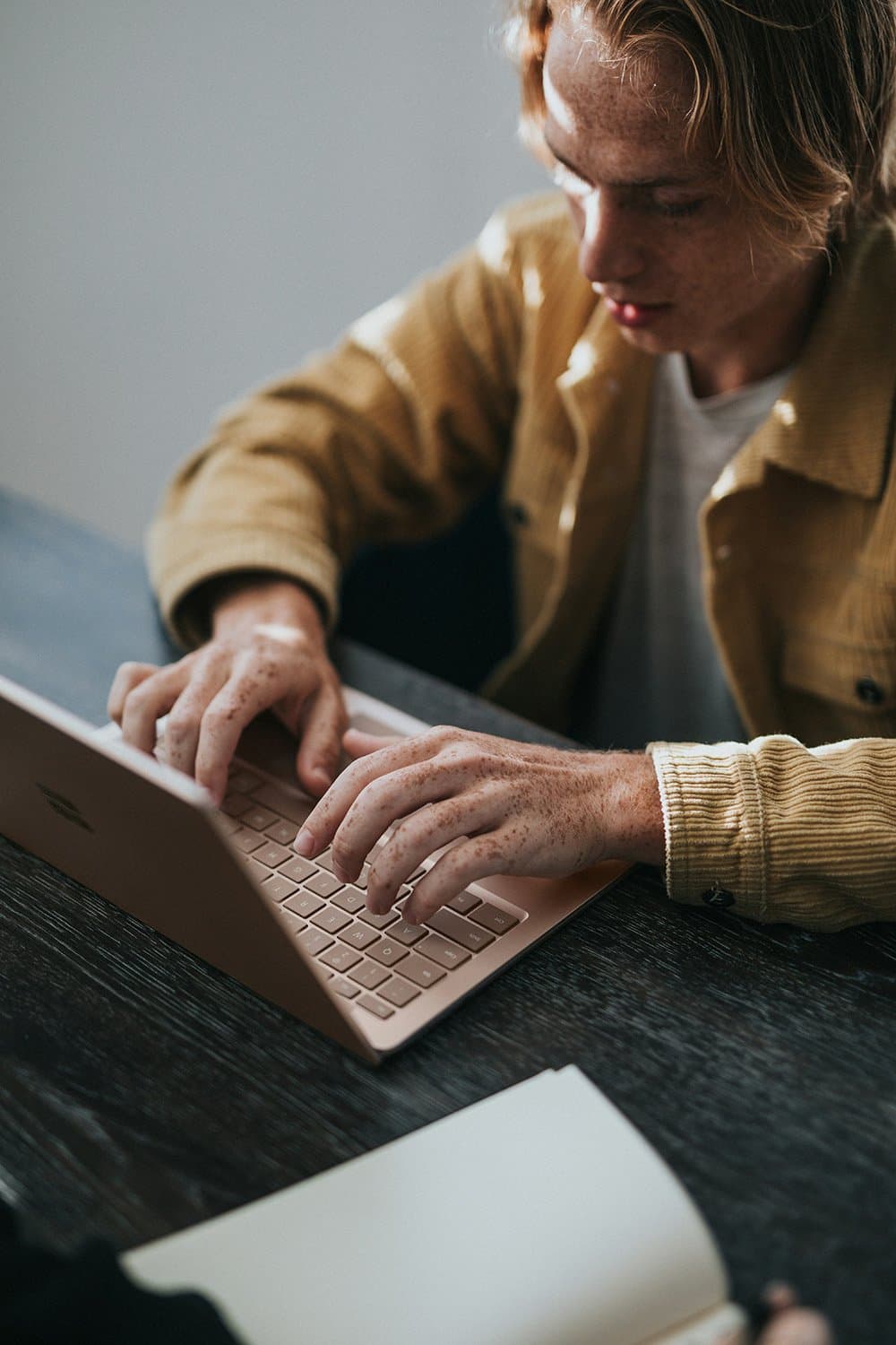 Hands typing on a laptop keyboard, seen from above