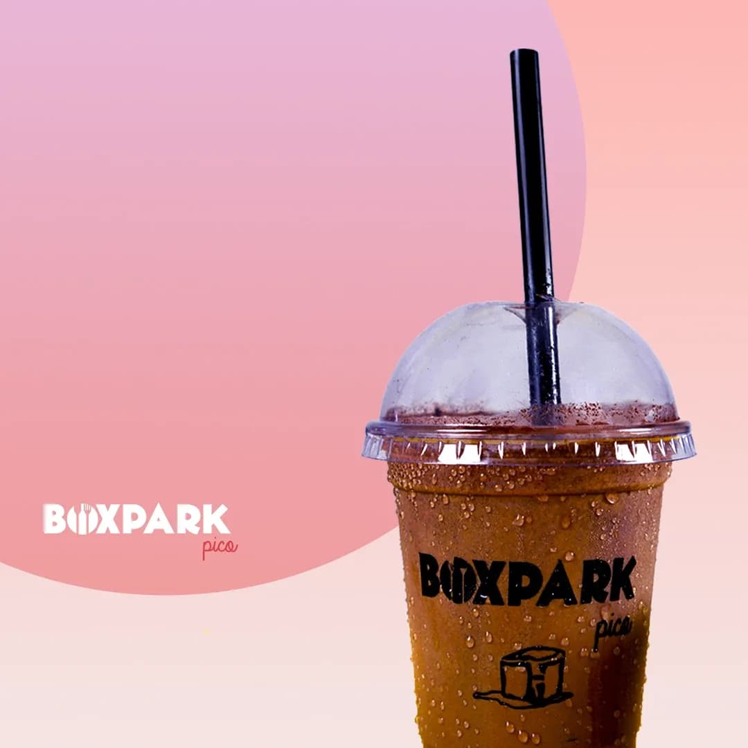 Iced coffee in a domed BoxPark Pico cup on a pink gradient background