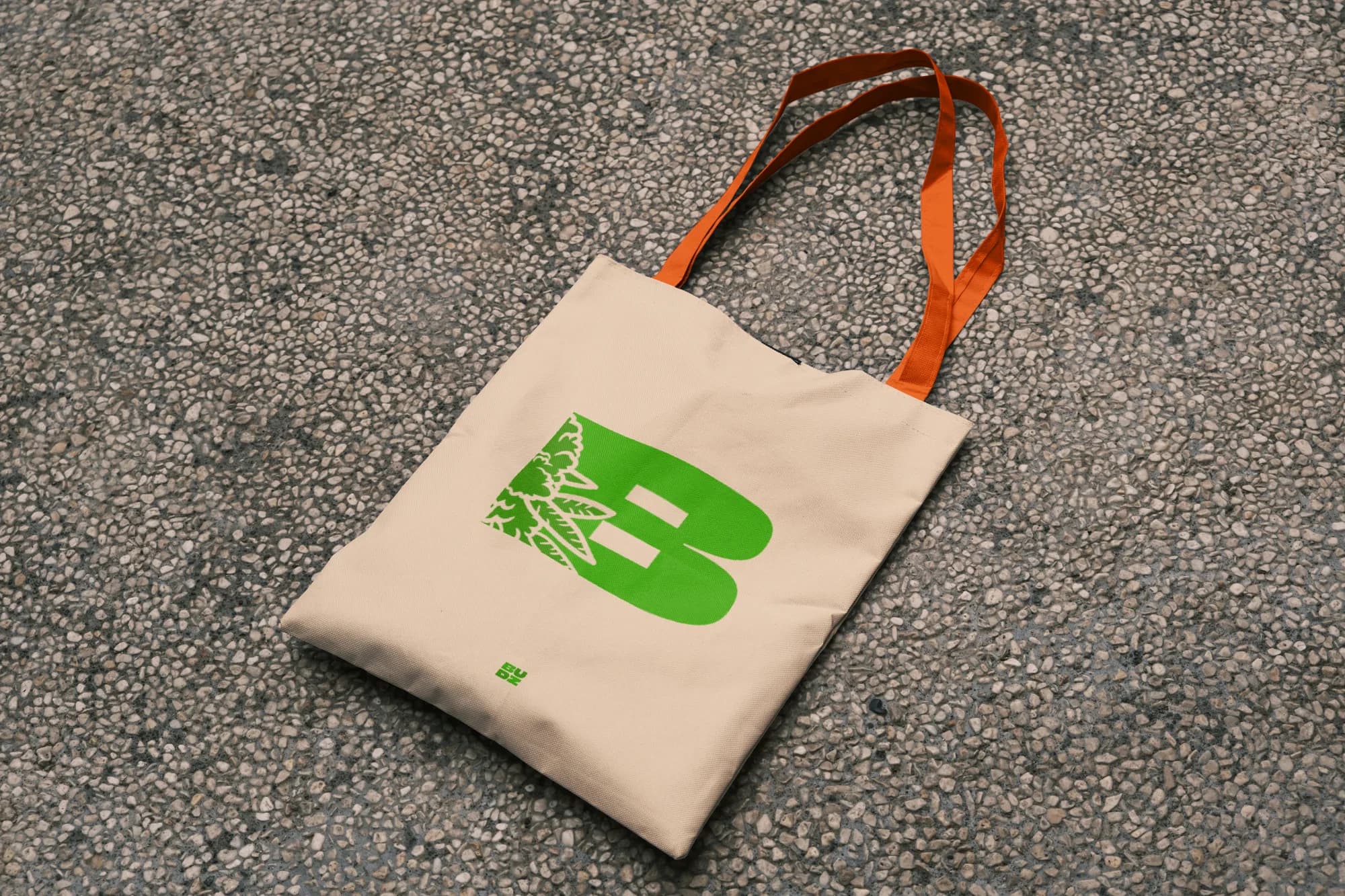 Canvas tote with orange straps and a green illustrated B mark