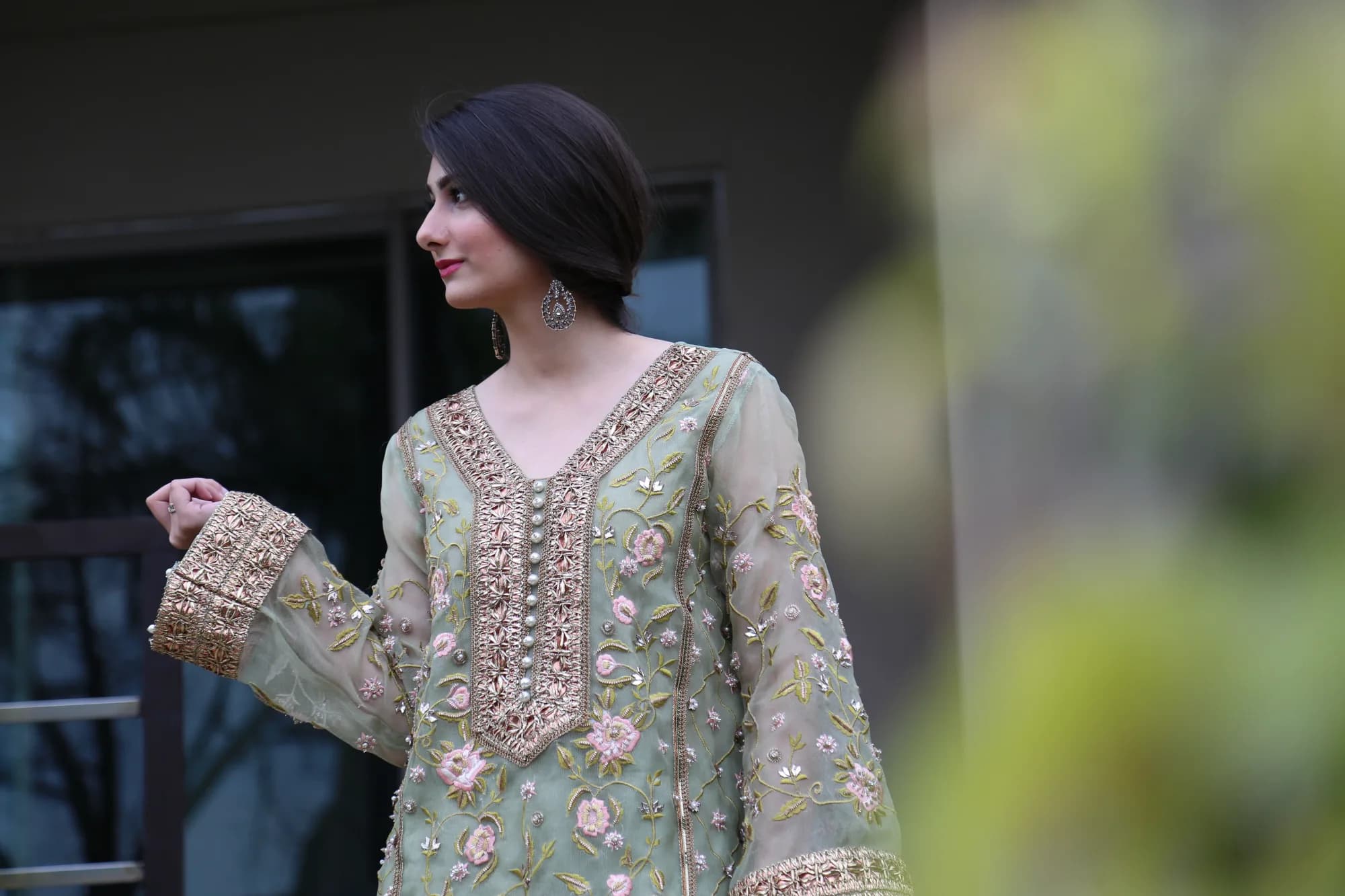 Model in a green floral embroidered kurta with gold neckline and cuffs
