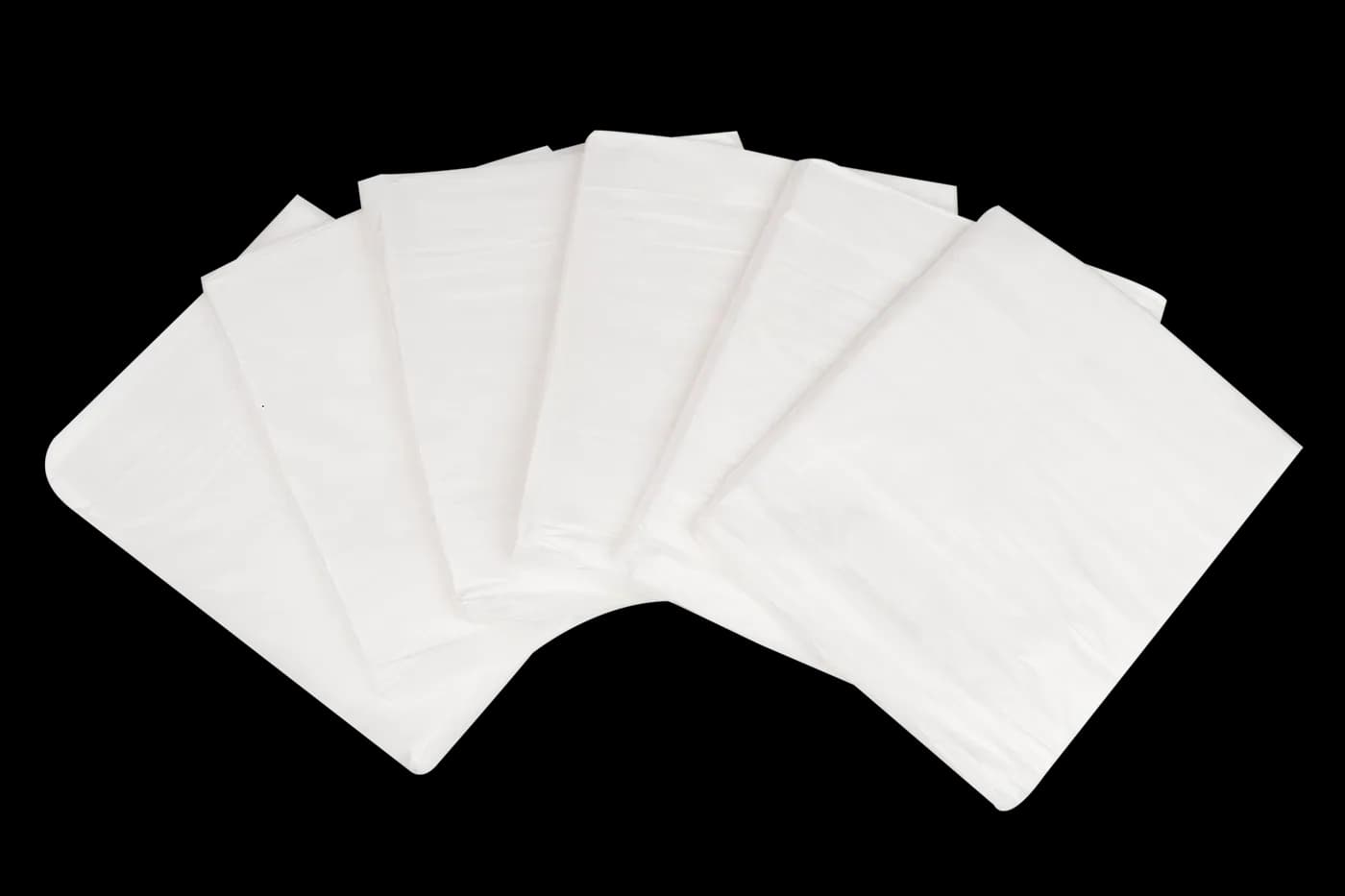 Fanned stack of folded dust sheets on black background