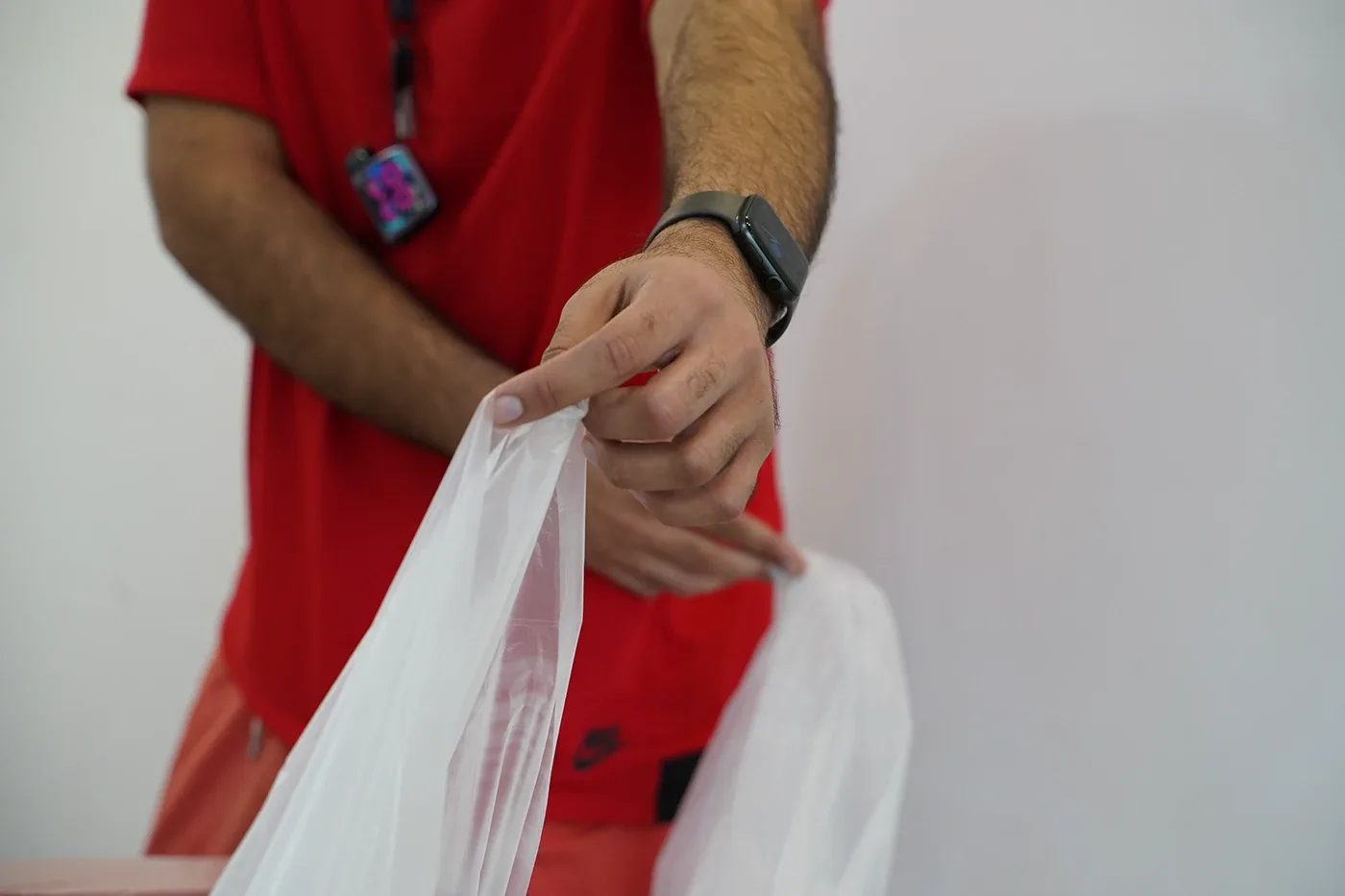 Hands unfolding a clear plastic dust sheet