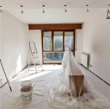Renovation room with furniture wrapped in a dust sheet