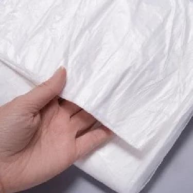 Hand holding the edge of a white dust sheet