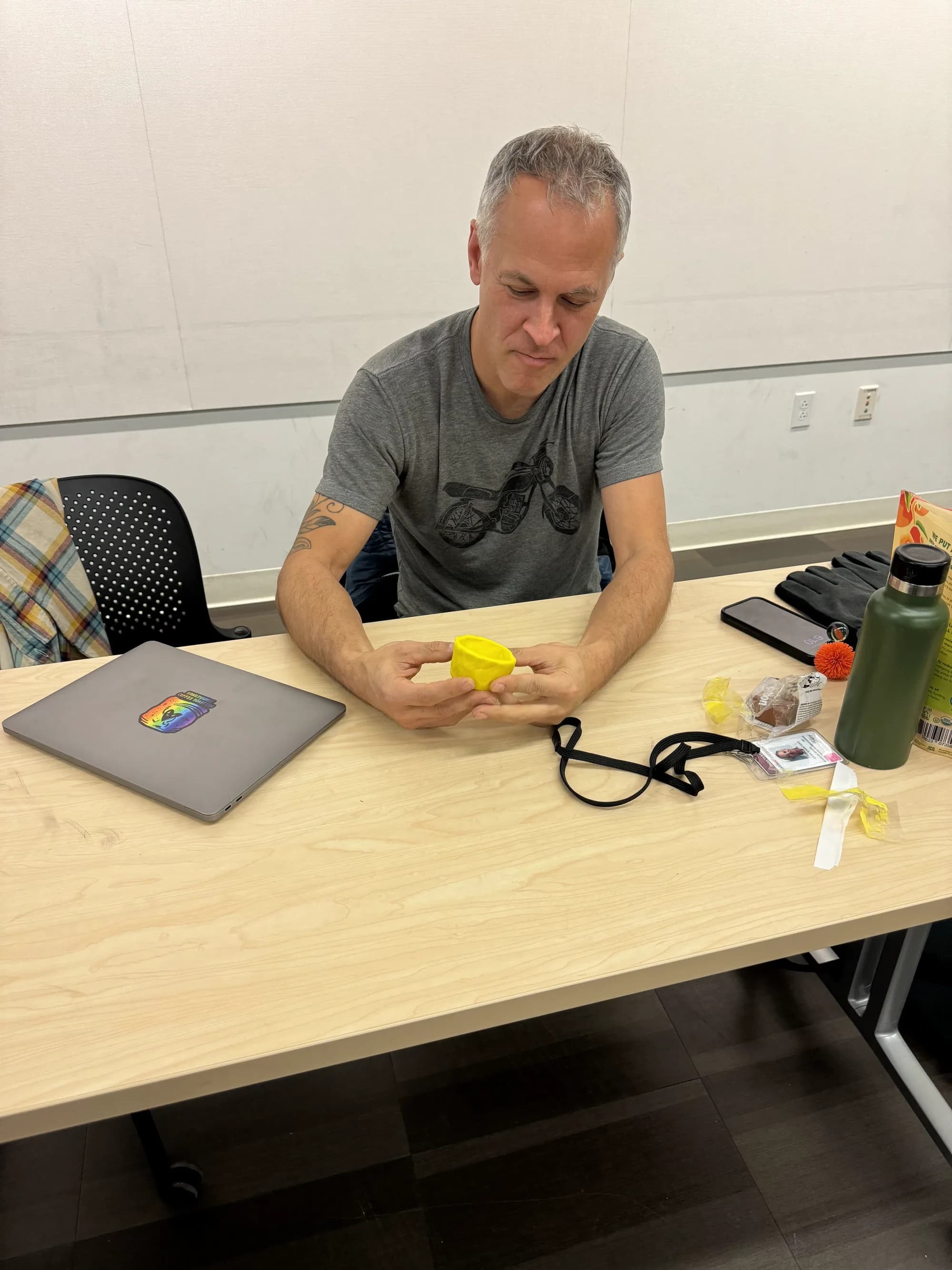Workshop participant shaping yellow clay at a table