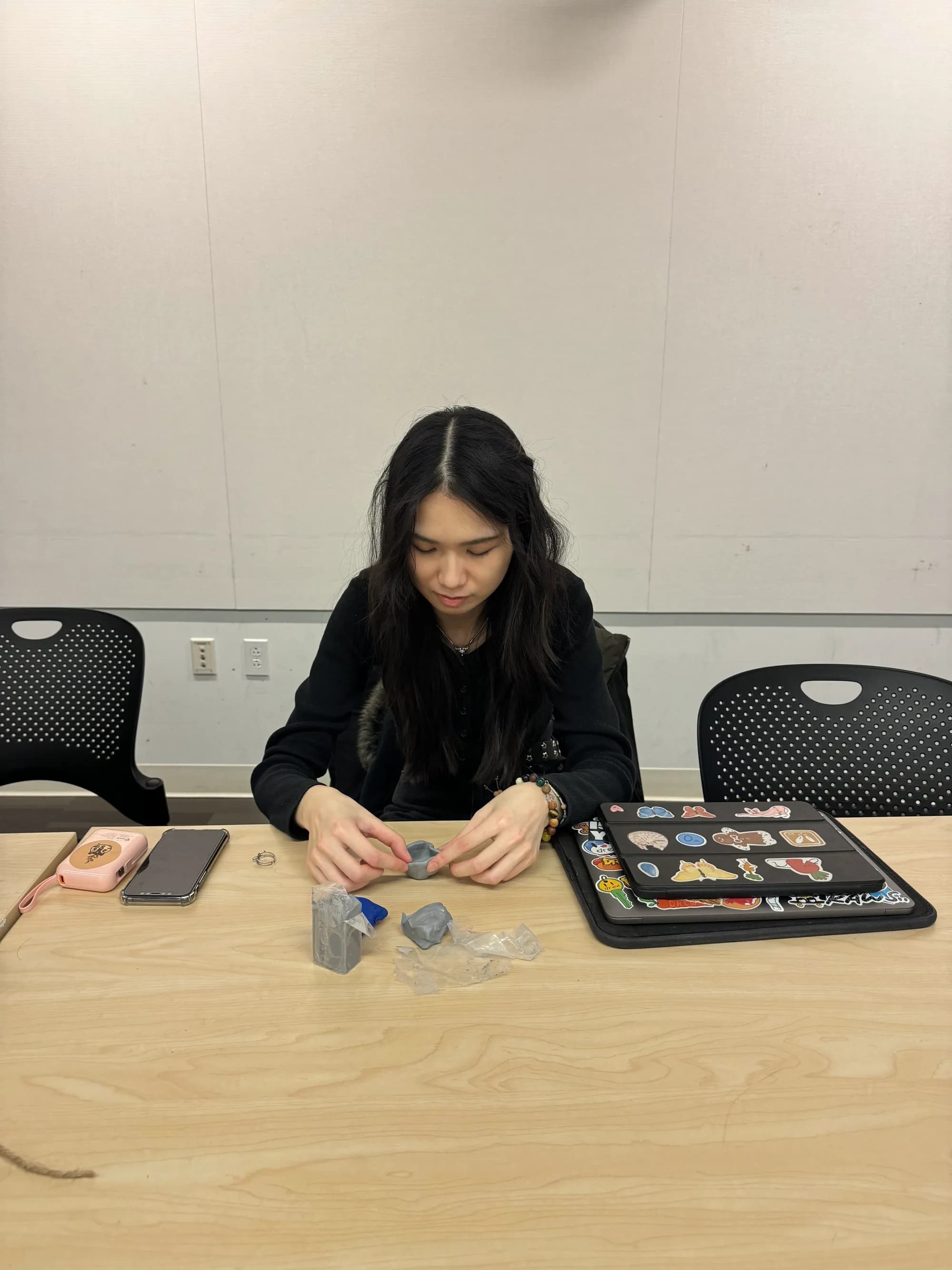Workshop participant shaping small clay pieces