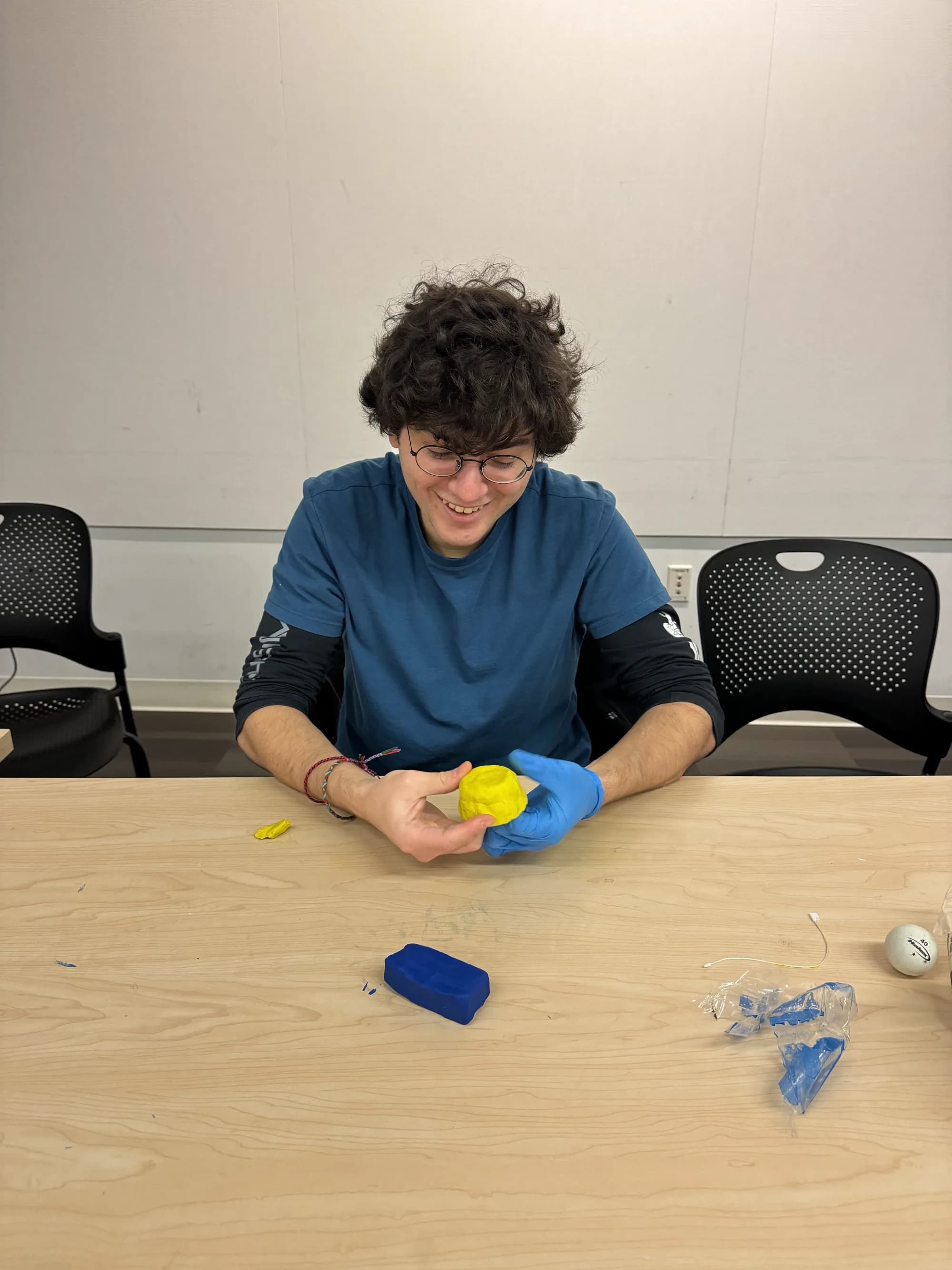 Workshop participant shaping yellow clay