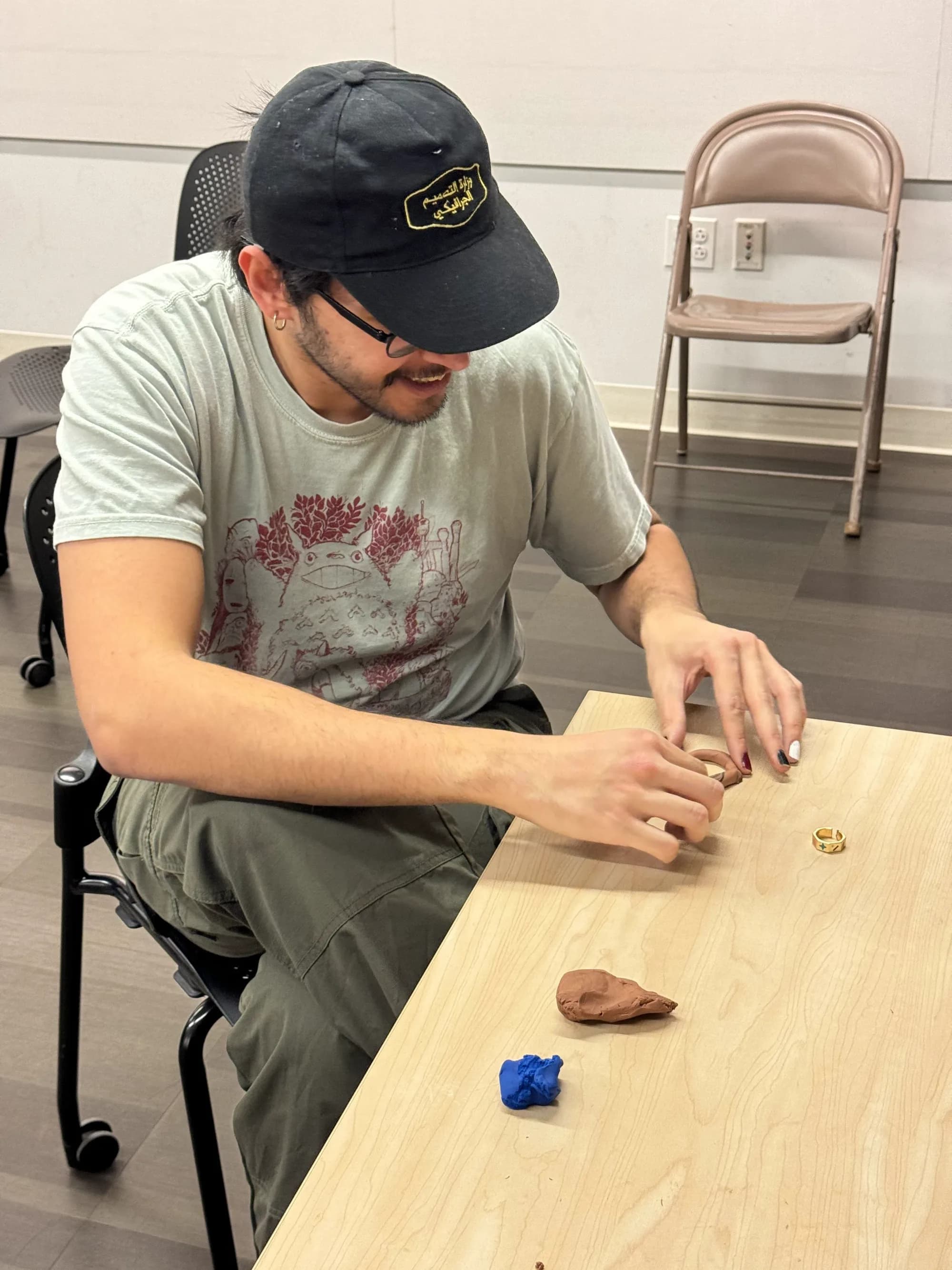 Workshop participant forming a small clay piece