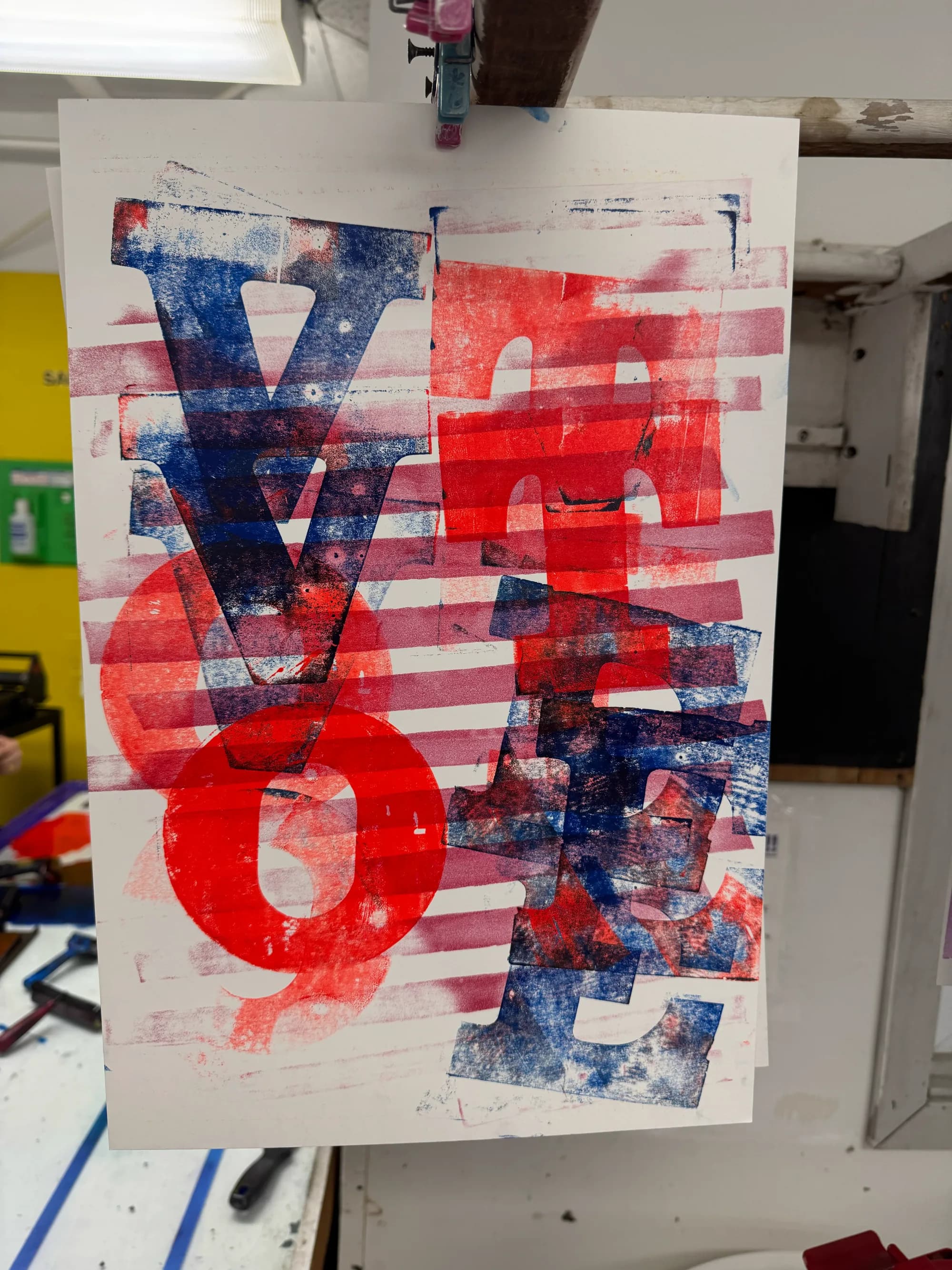 Layered red and blue Vote poster hanging to dry