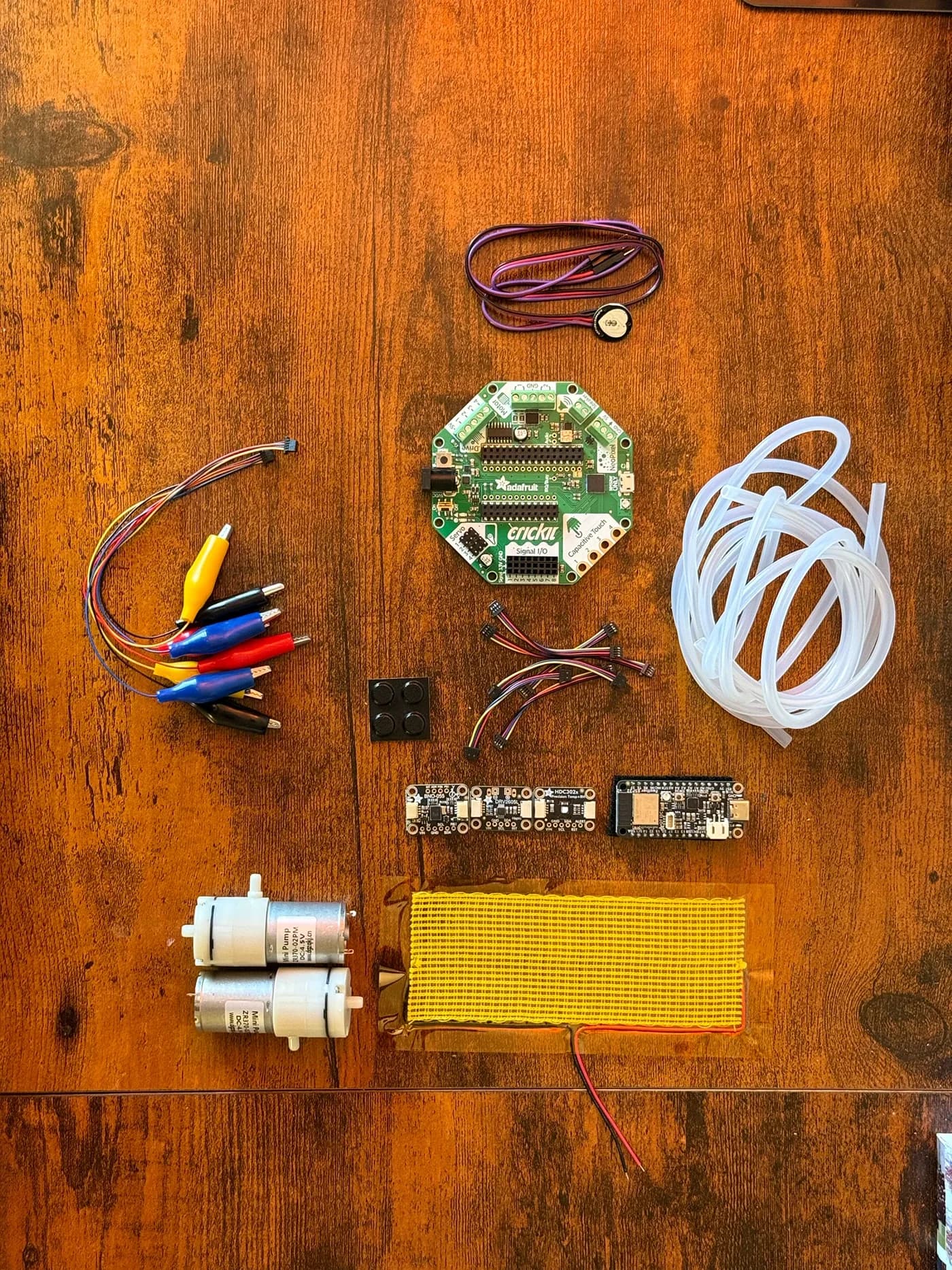 Components laid out: board, pumps, tubing, heating pad, wires