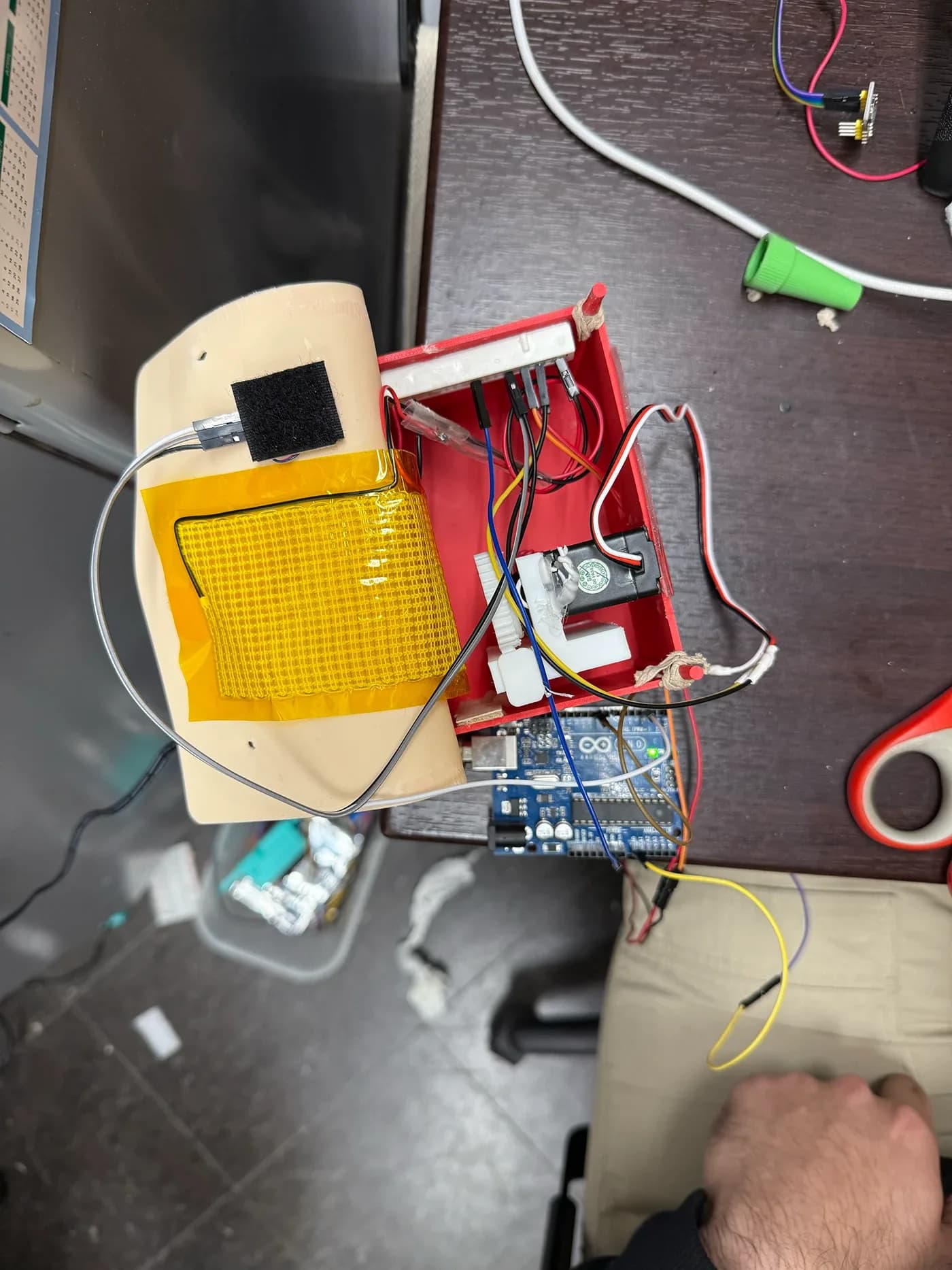 Top view of a red 3D-printed enclosure with heating pad and wiring