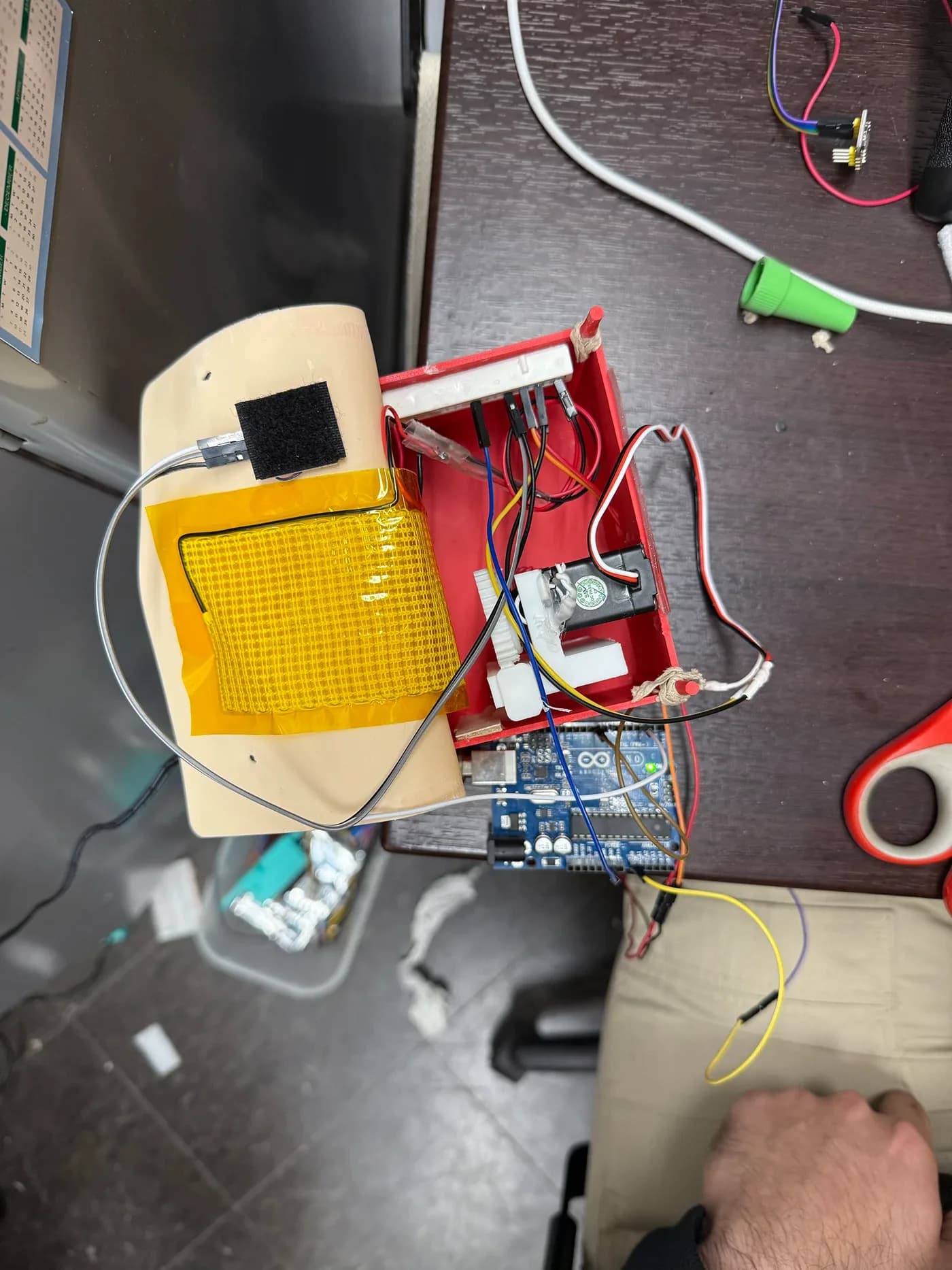 Red enclosure with electronics beside a latex pillow surface