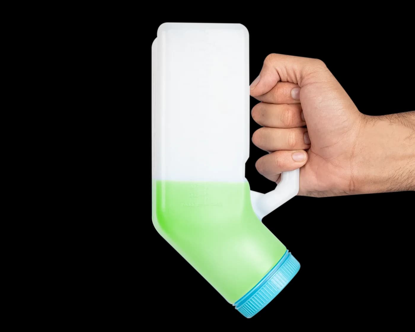 Hand holding the tilted bottle with green liquid
