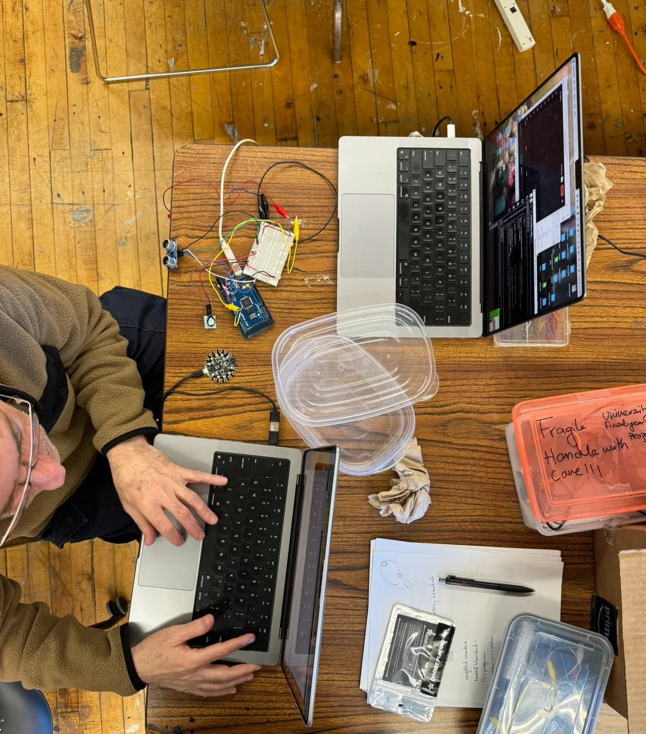 Overhead view of laptops, sensors and prototyping materials on a table