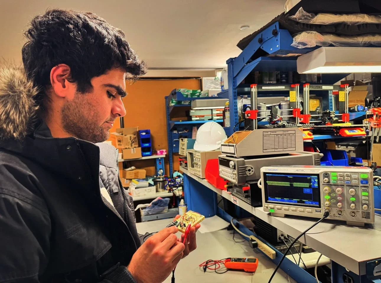 Inspecting a circuit board beside an oscilloscope in the lab