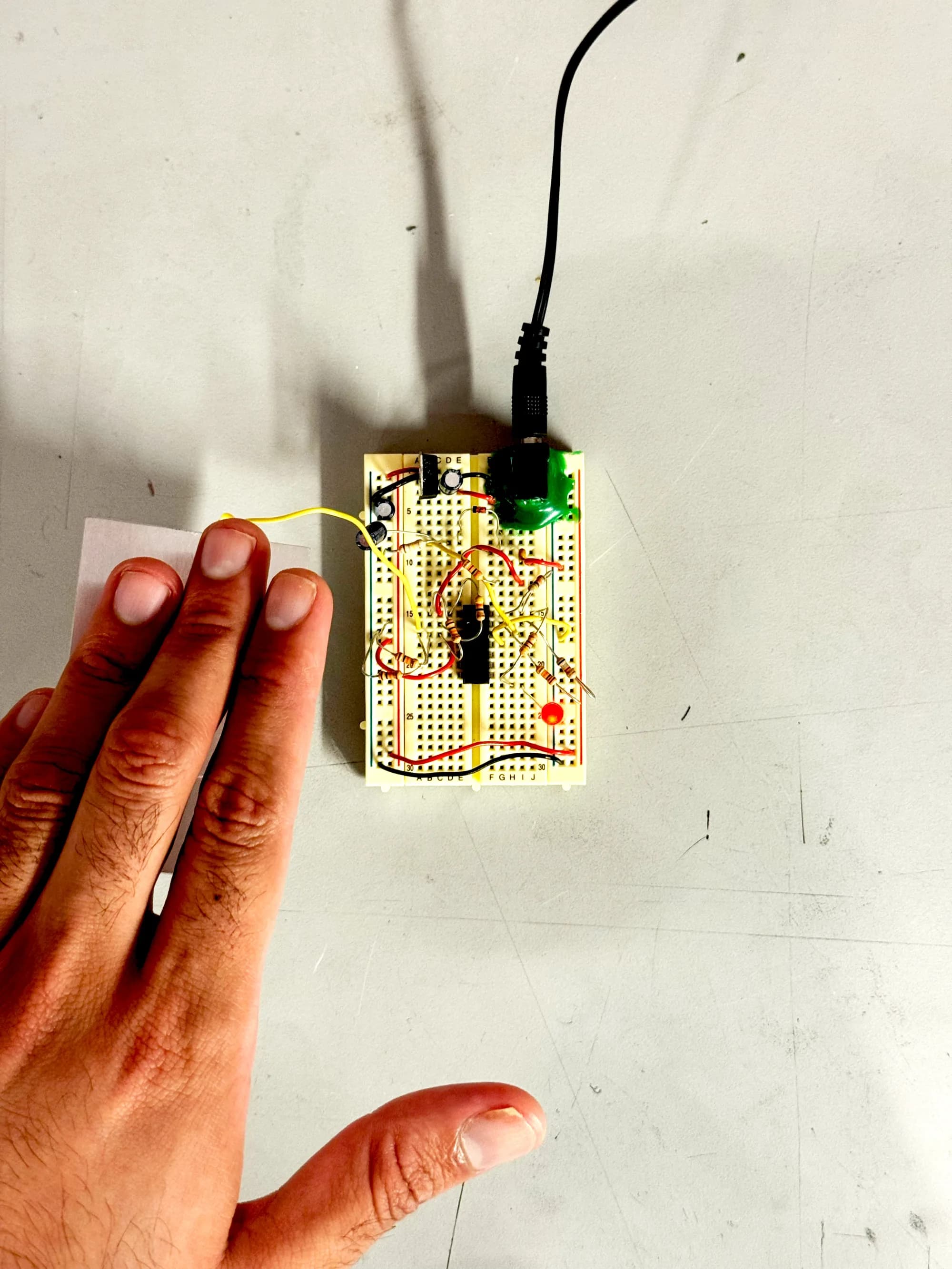 Hand touching the metal plate of a capacitive sensor circuit