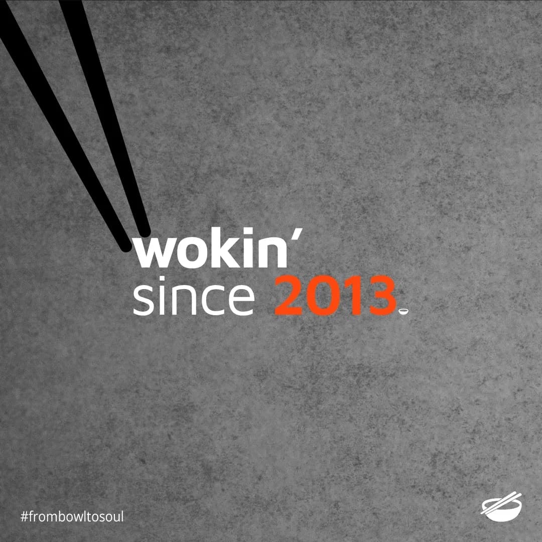 Chopsticks with text 'wokin' since 2013' on concrete texture