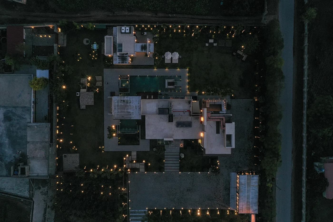 Overhead night aerial of the house with garden lights