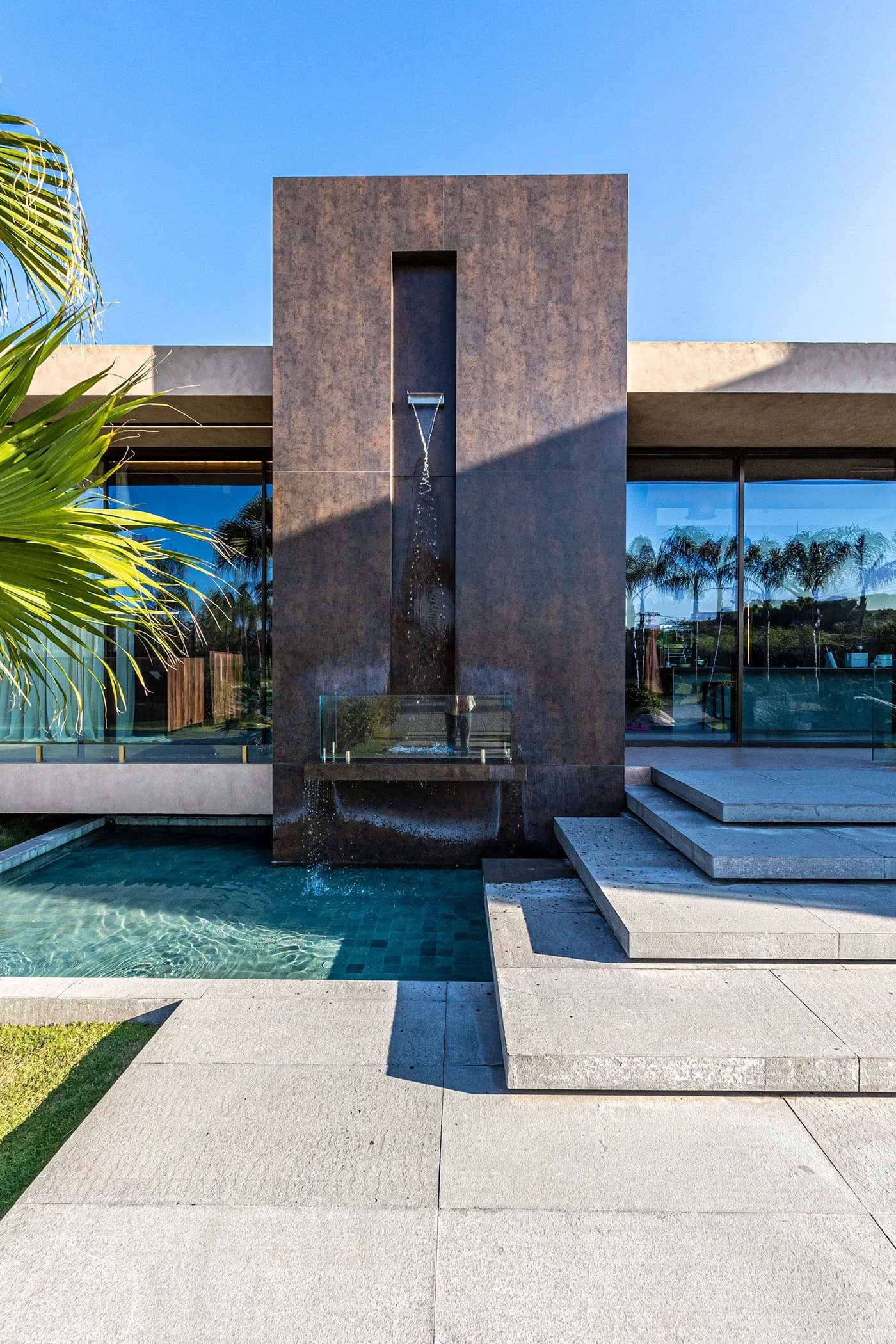 Bronze water feature wall above a reflecting pool