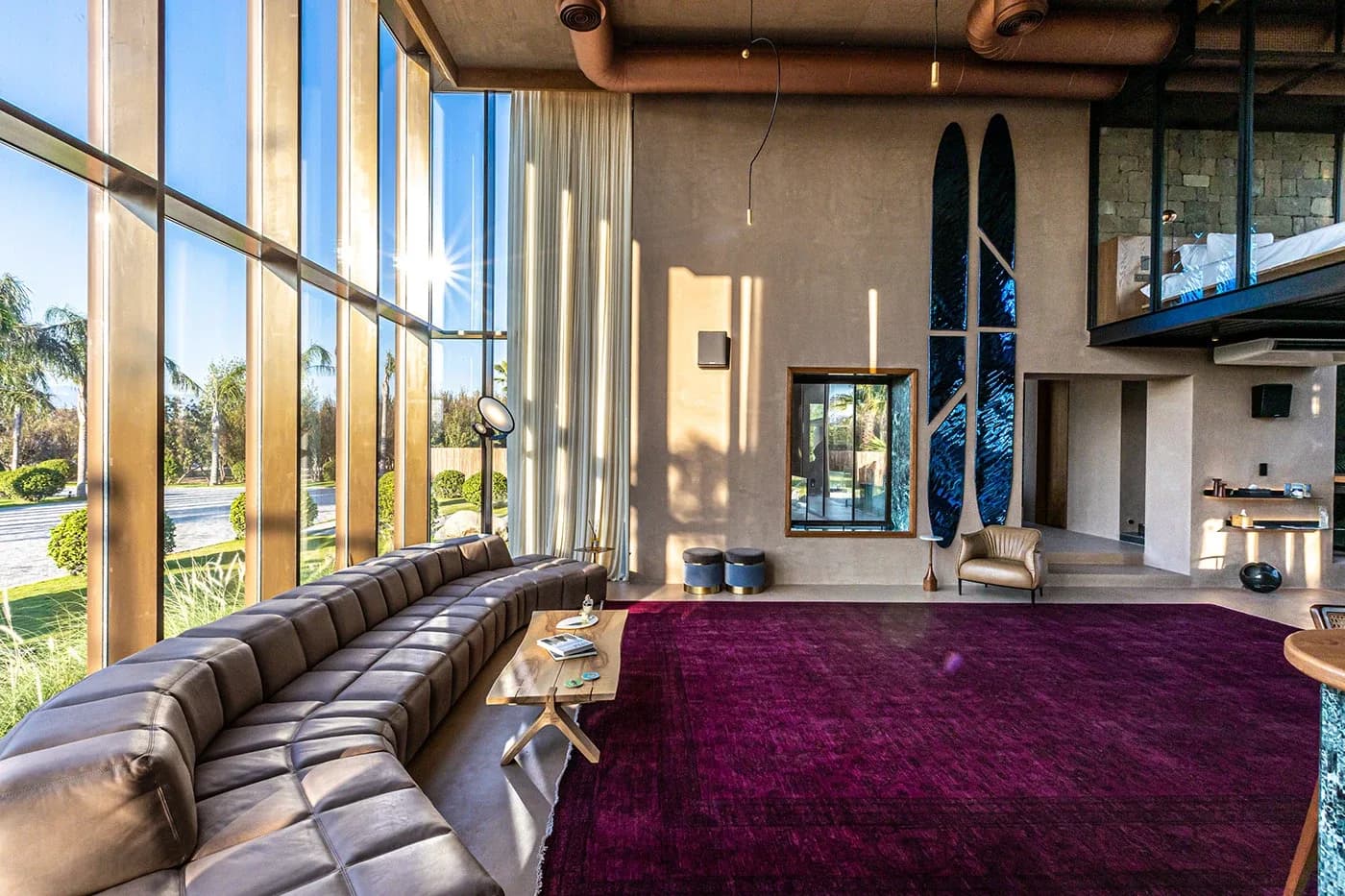 Living room with long curved leather sofa and tall windows