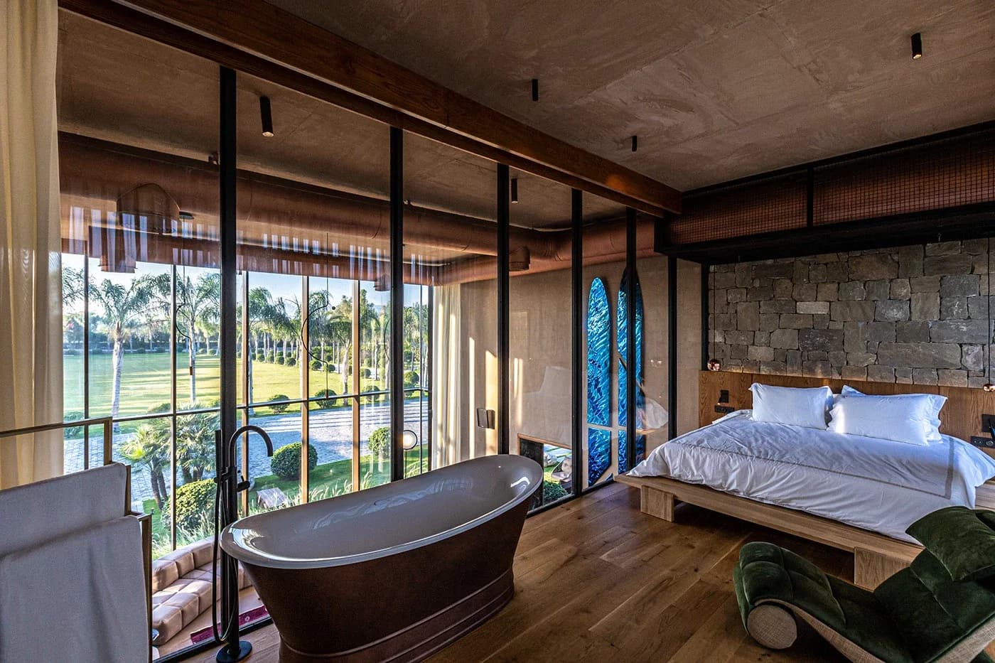 Bedroom with bathtub by windows overlooking the lawn