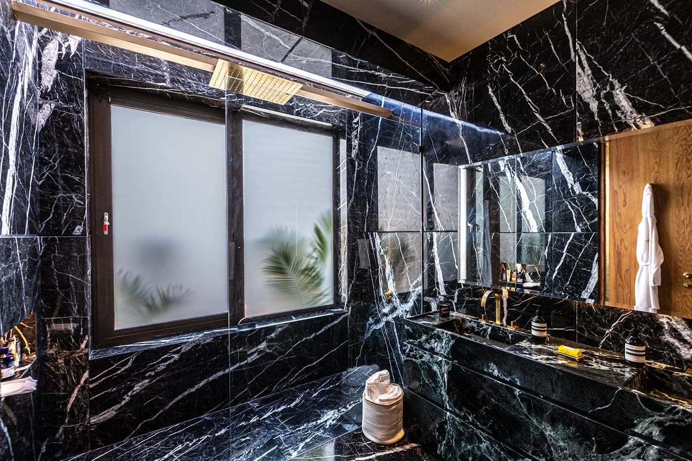 Black marble bathroom with vanity and frosted windows