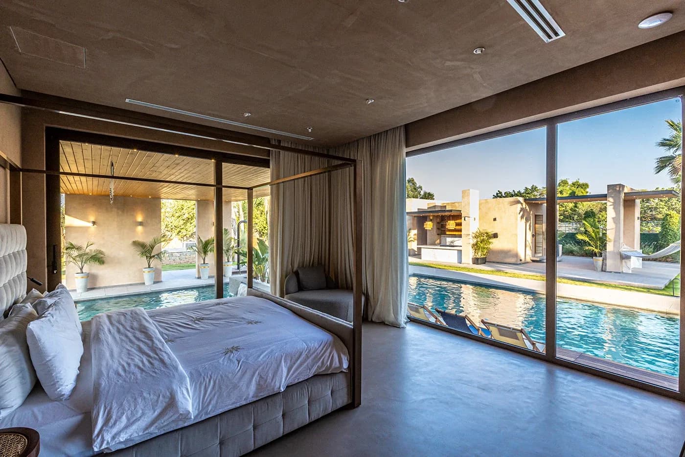 Four-poster bedroom opening onto the pool