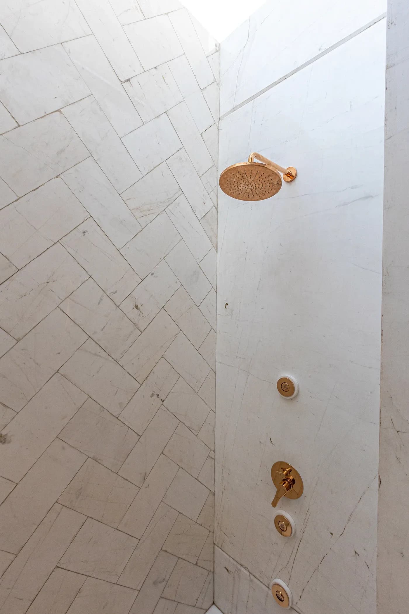 White marble shower with rose-gold fittings
