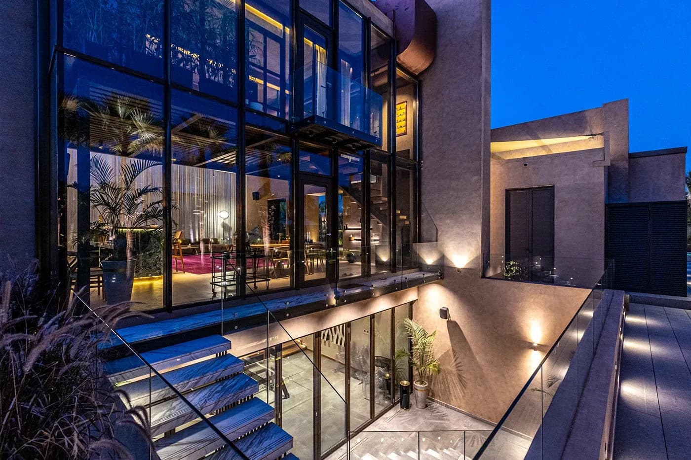 Glass facade and floating stairs lit at night