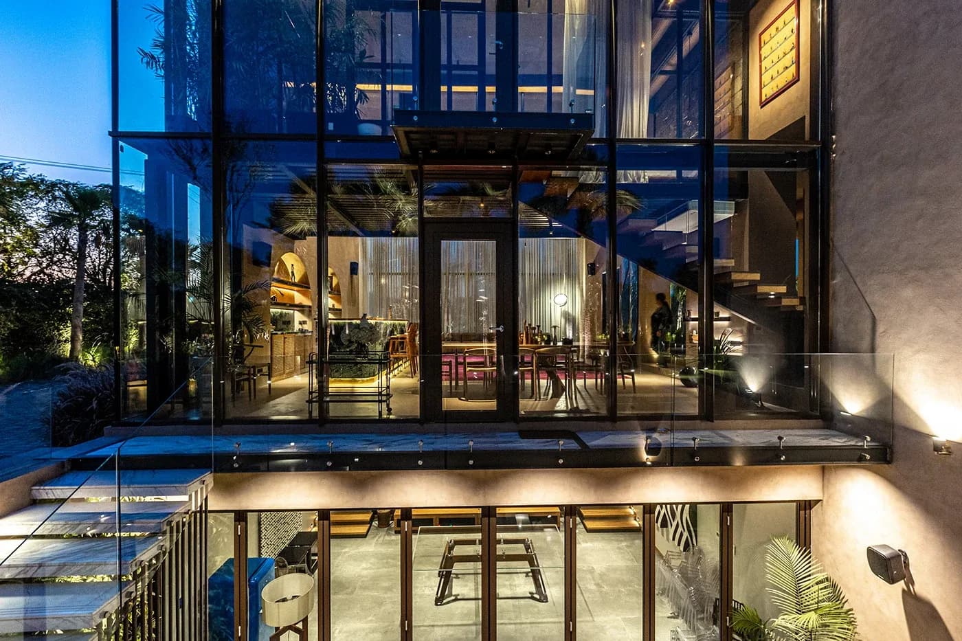 Multi-level glass facade with lower level revealed at night