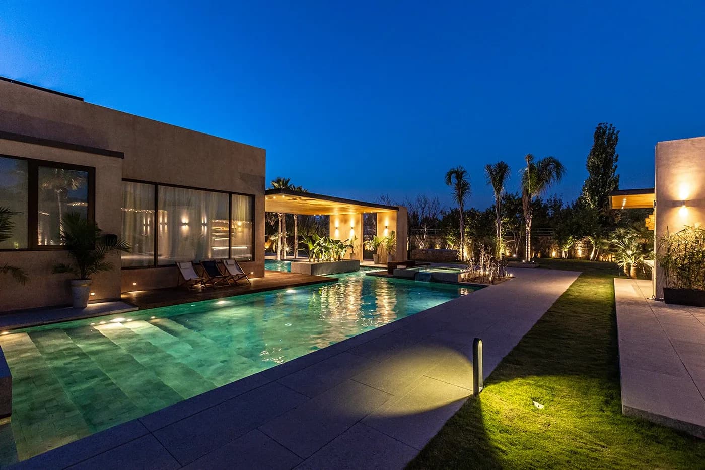 Lit pool beside the house at blue hour