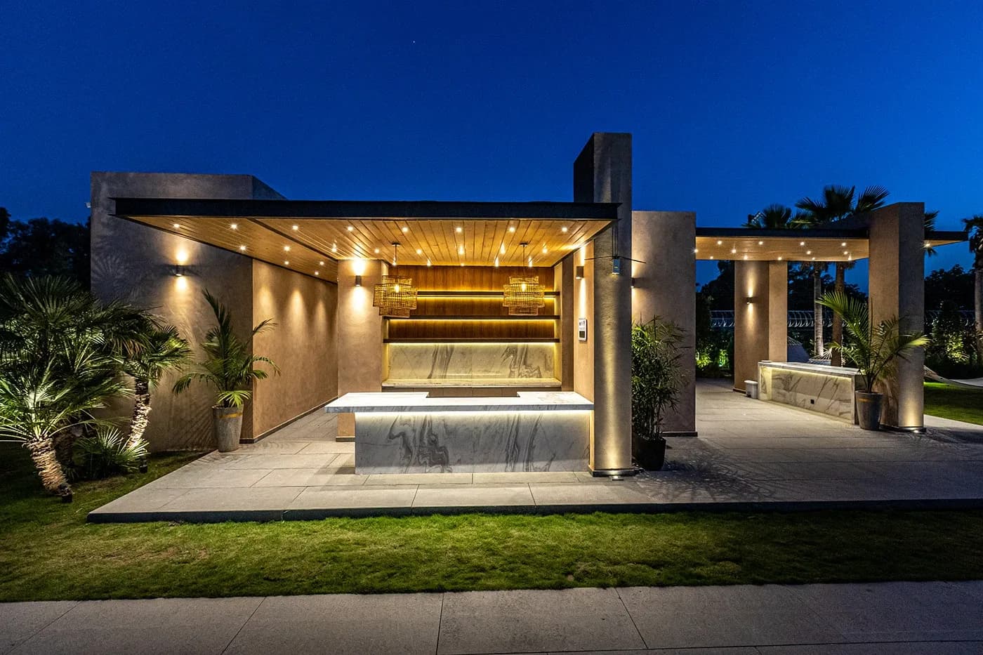 Outdoor pavilion with lit wood ceiling at night