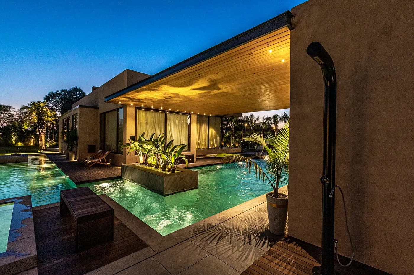 Covered pool deck with outdoor shower at night
