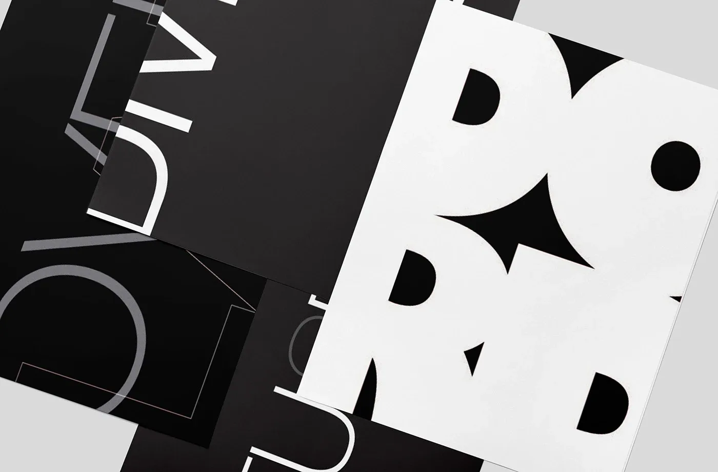 Close, angled view of overlapping typographic posters with large letters